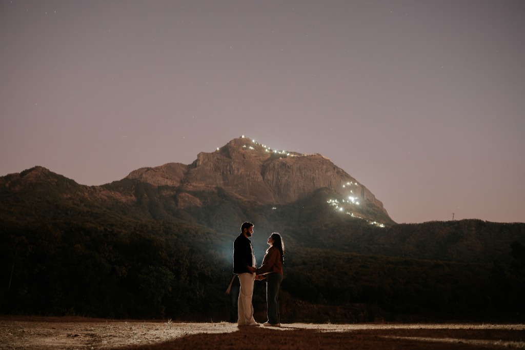 Couple under mountain night sky